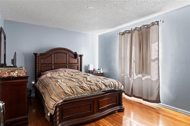 bedroom with hardwood / wood-style floors and a textured ceiling