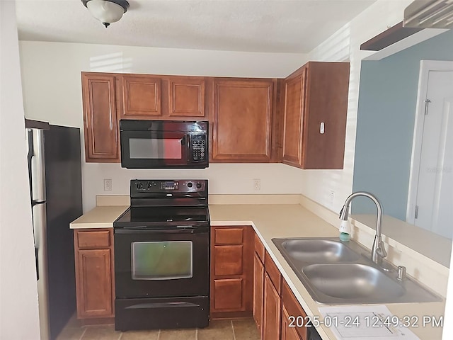 kitchen with sink, light tile patterned floors, and black appliances