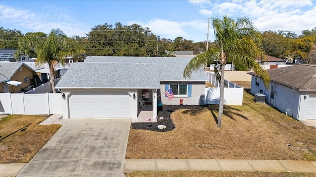 ranch-style home with a garage, a front yard, and central AC unit