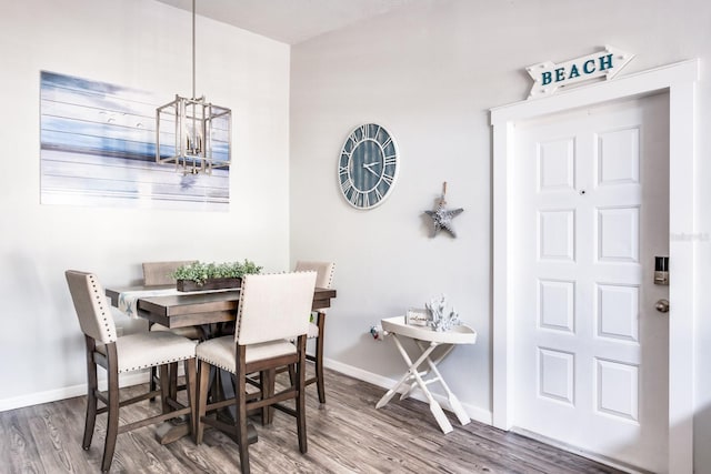 dining area featuring wood-type flooring and a notable chandelier