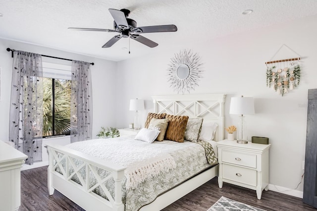 bedroom featuring dark hardwood / wood-style flooring, ceiling fan, and a textured ceiling