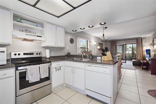 kitchen with sink, white cabinets, light tile patterned floors, kitchen peninsula, and white appliances