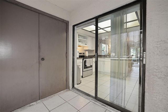 interior space featuring sink, a healthy amount of sunlight, and light tile patterned flooring