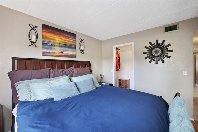 bedroom featuring a walk in closet and a textured ceiling