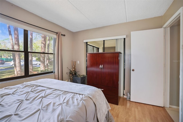 bedroom with light hardwood / wood-style floors and a textured ceiling