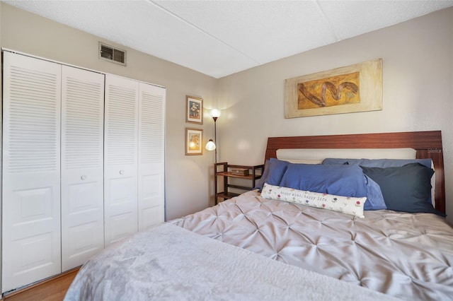 bedroom with wood-type flooring, a closet, and a textured ceiling