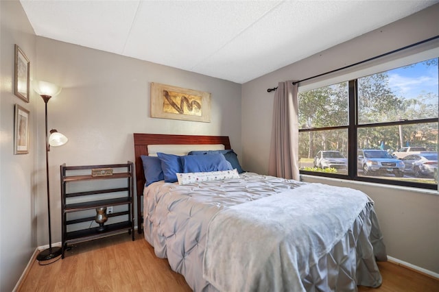 bedroom with light hardwood / wood-style floors and a textured ceiling