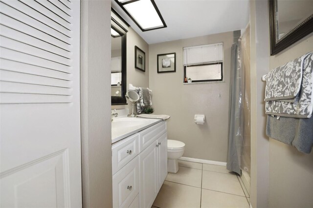 bathroom with walk in shower, vanity, toilet, and tile patterned flooring