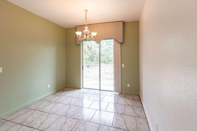 unfurnished room featuring a chandelier