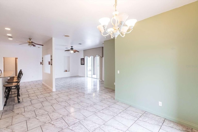 spare room with ceiling fan with notable chandelier