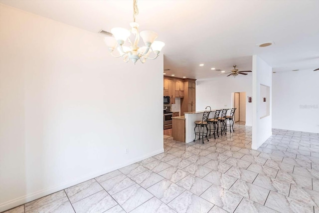 interior space with electric stove, hanging light fixtures, ceiling fan with notable chandelier, and a breakfast bar