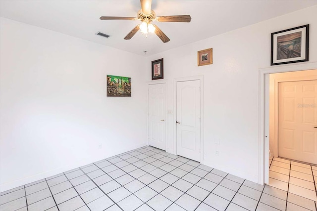 empty room featuring ceiling fan and light tile patterned floors