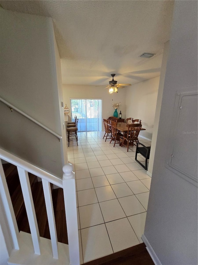 tiled dining space with ceiling fan