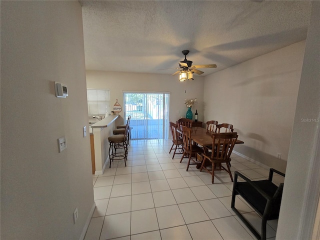 tiled dining room featuring a textured ceiling and ceiling fan