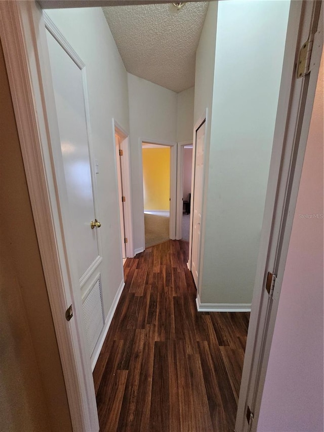 hallway featuring dark hardwood / wood-style flooring and a textured ceiling