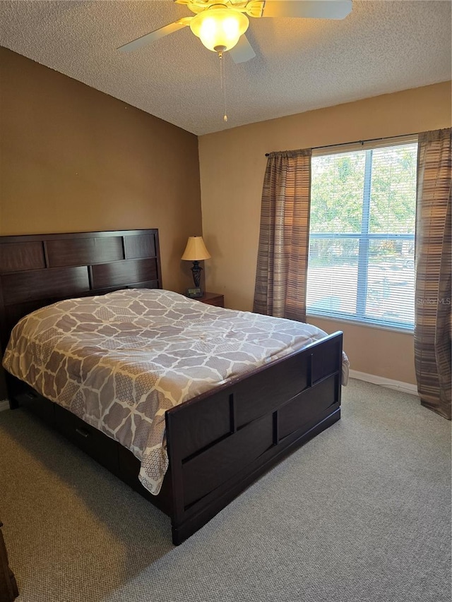 carpeted bedroom featuring a textured ceiling and ceiling fan