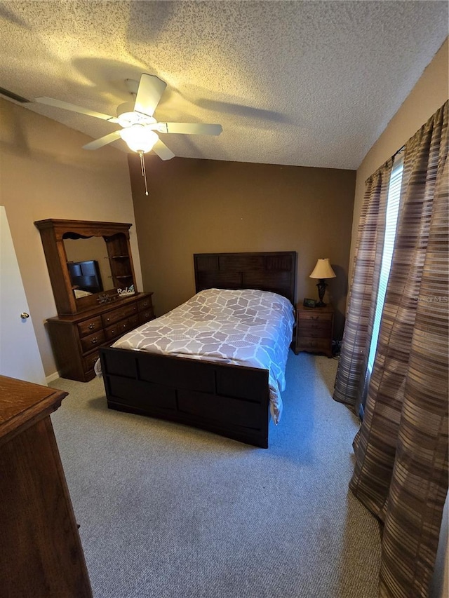 bedroom with light colored carpet, a textured ceiling, and ceiling fan