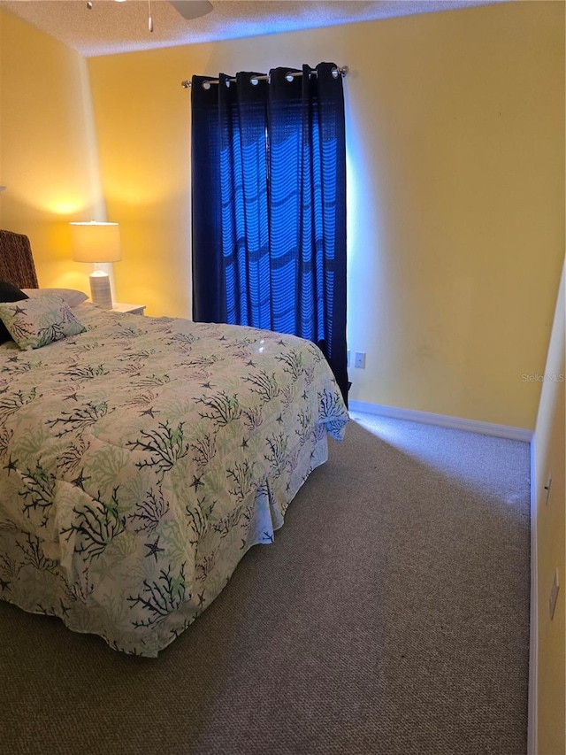 carpeted bedroom featuring a textured ceiling and ceiling fan