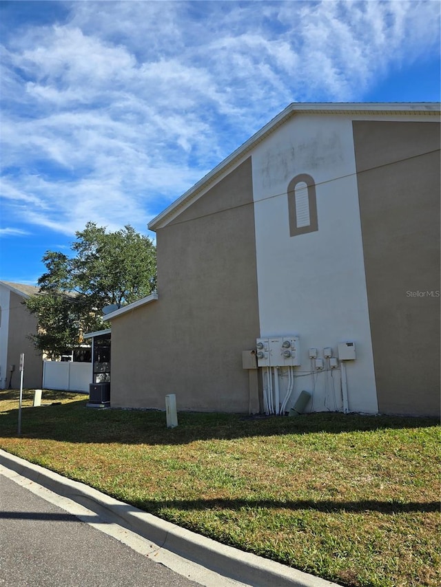 view of home's exterior featuring cooling unit and a lawn