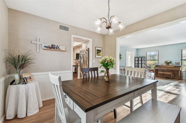 dining room with a notable chandelier and light wood-type flooring