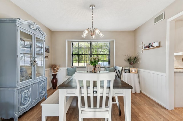 dining area featuring an inviting chandelier, hardwood / wood-style flooring, and a textured ceiling