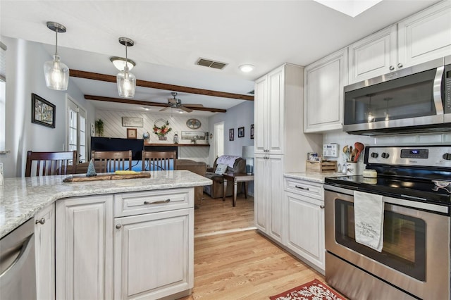 kitchen with stainless steel appliances, white cabinetry, hanging light fixtures, and light stone counters