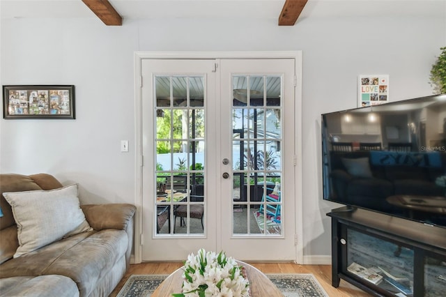 doorway to outside with beamed ceiling, light wood-type flooring, and french doors