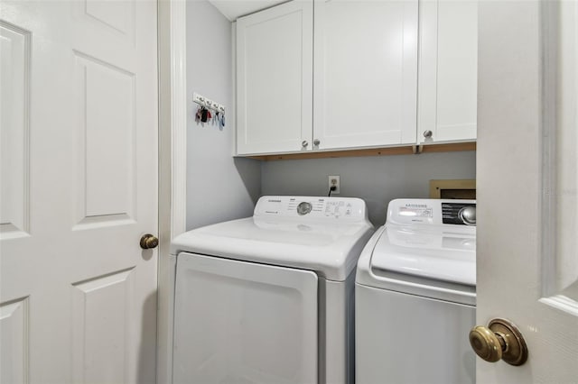 laundry room with washer and clothes dryer and cabinets