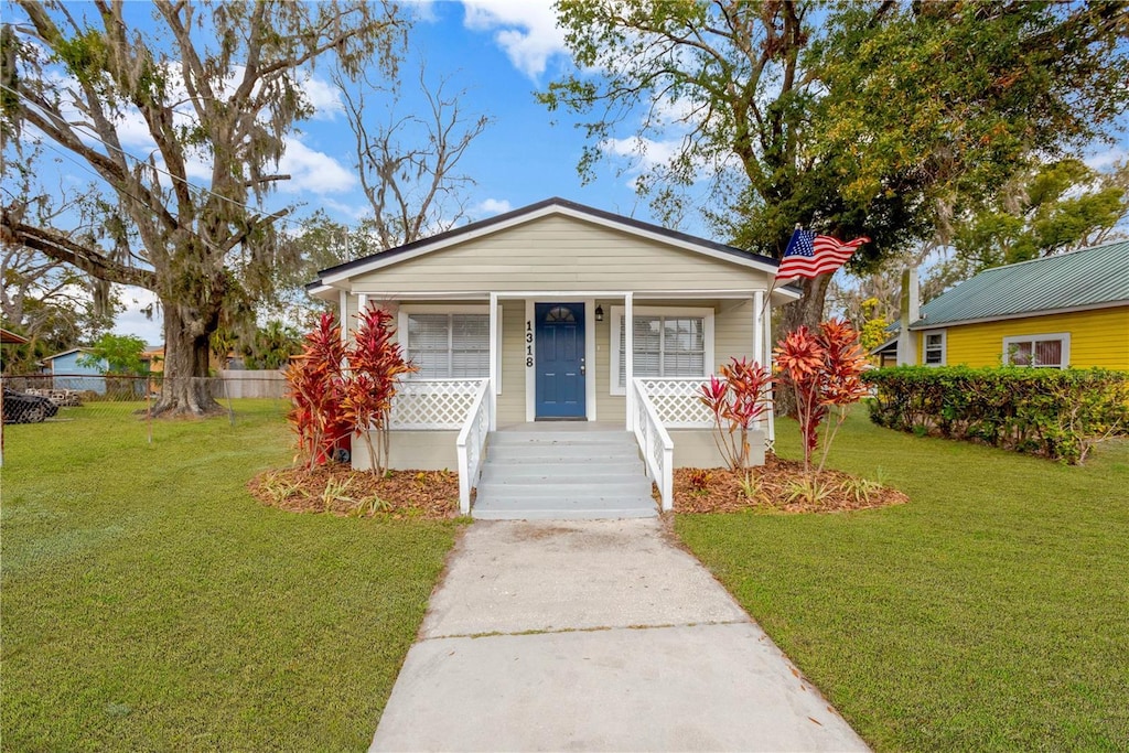 bungalow-style house with covered porch and a front yard