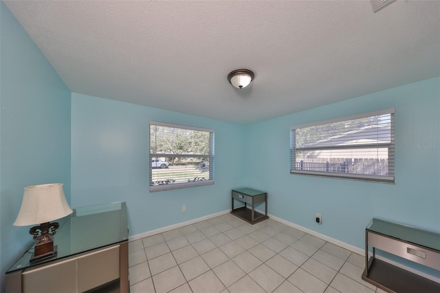 sitting room featuring a wealth of natural light, a textured ceiling, and light tile patterned floors