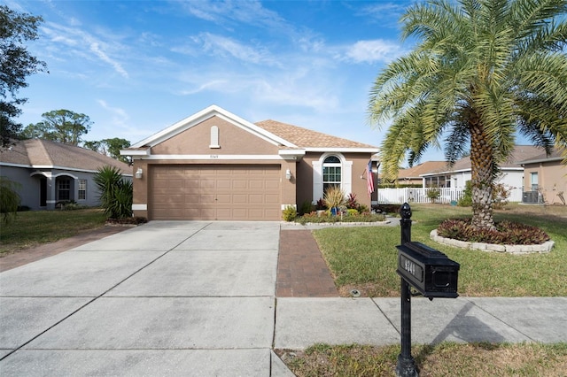 ranch-style home with a garage, central AC unit, and a front yard