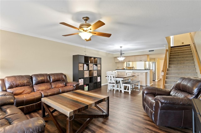 living room with crown molding, ceiling fan, and dark wood-type flooring