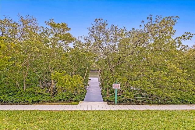 view of dock with a lawn