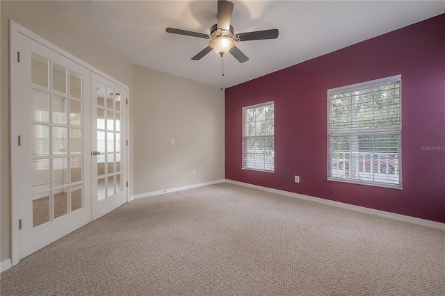 carpeted spare room with ceiling fan and french doors