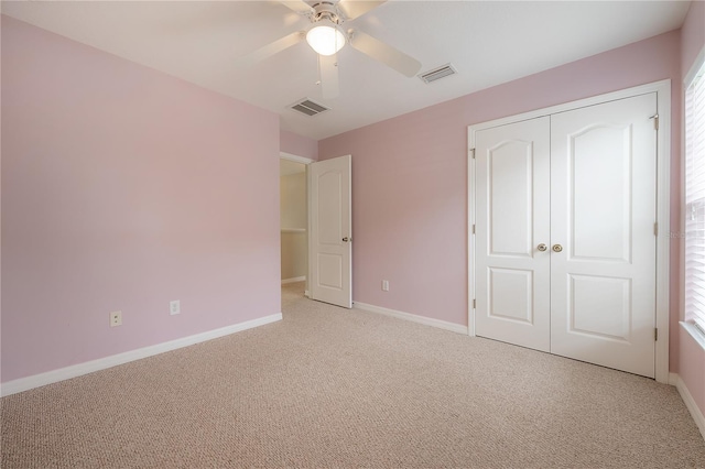 unfurnished bedroom featuring light carpet, ceiling fan, and a closet