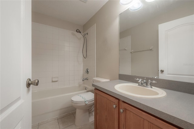 full bathroom featuring tile patterned flooring, vanity, tiled shower / bath combo, and toilet