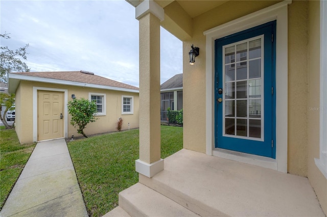 entrance to property featuring a yard