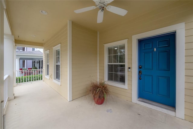 entrance to property featuring ceiling fan and a porch