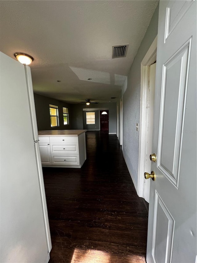 hallway featuring dark hardwood / wood-style floors and a textured ceiling