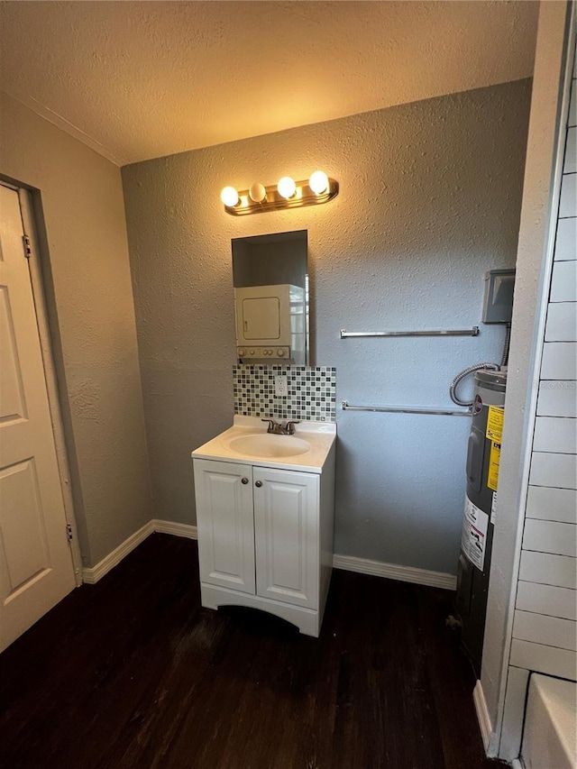 bathroom featuring hardwood / wood-style floors, water heater, backsplash, vanity, and a textured ceiling