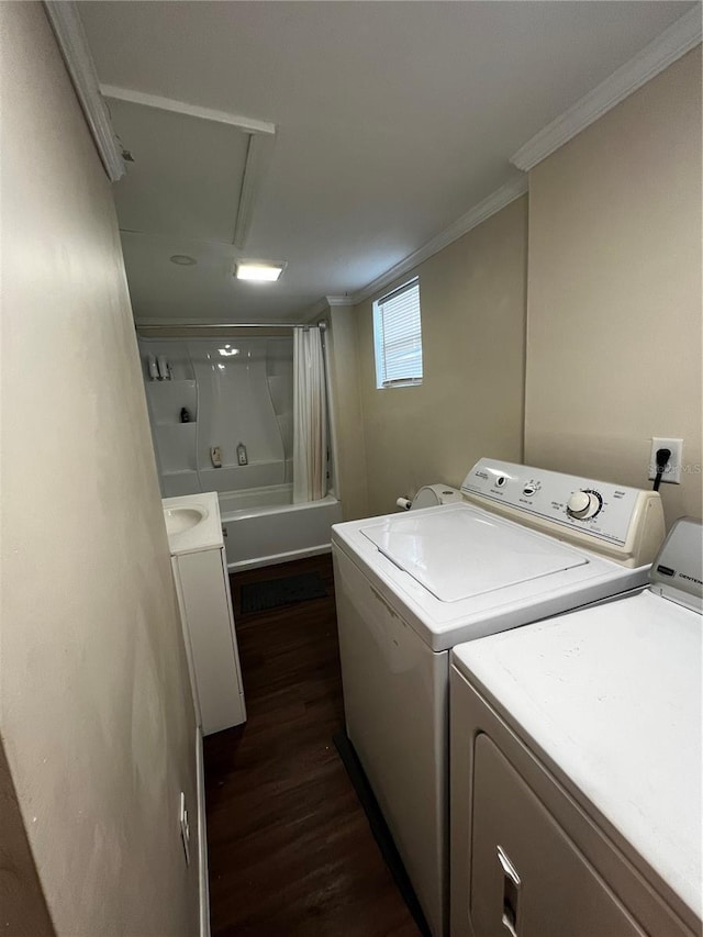 washroom with crown molding, dark hardwood / wood-style floors, and washer and clothes dryer