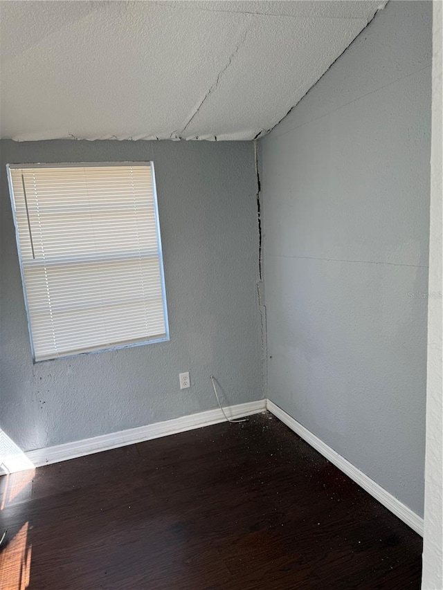 unfurnished room with hardwood / wood-style floors and a textured ceiling