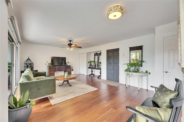 living room featuring wood-type flooring and ceiling fan