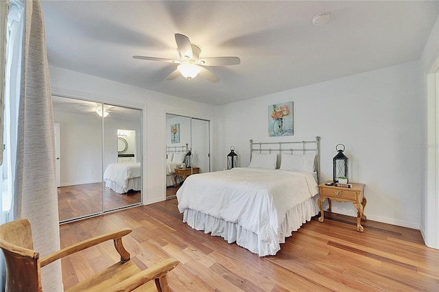 bedroom featuring ceiling fan, hardwood / wood-style flooring, and multiple closets