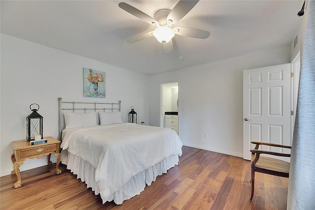 bedroom with hardwood / wood-style flooring, ensuite bath, and ceiling fan