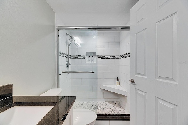 bathroom featuring sink, an enclosed shower, and toilet