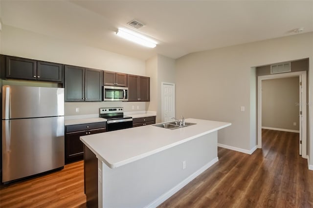 kitchen featuring dark wood-type flooring, stainless steel appliances, sink, and an island with sink