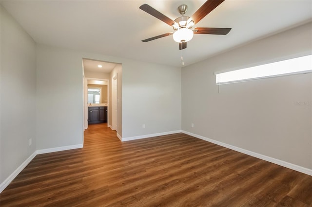 empty room featuring dark wood-type flooring and ceiling fan