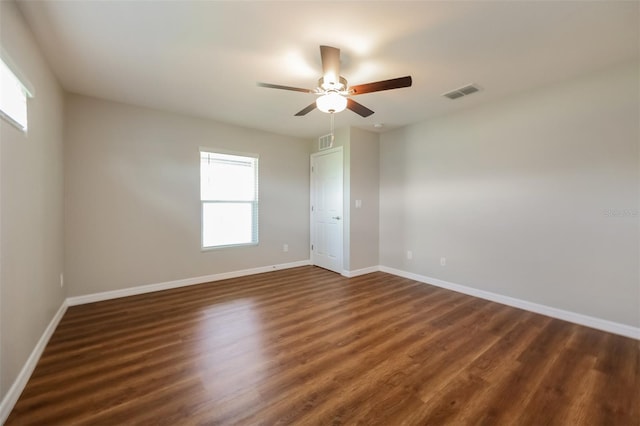 spare room with dark wood-type flooring, ceiling fan, and plenty of natural light