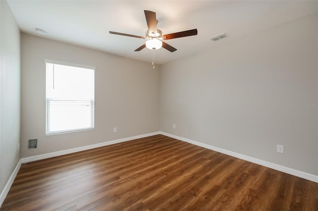 unfurnished room featuring dark wood-type flooring and ceiling fan